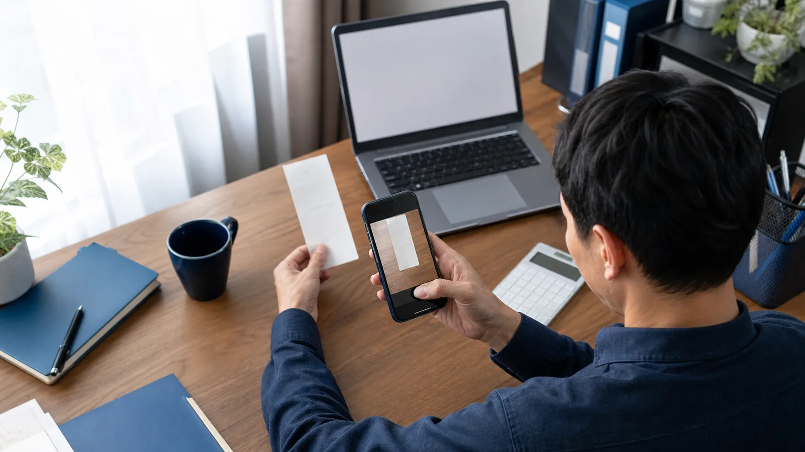 スマートフォンで領収書を撮影し内容を確認する日本の個人事業主